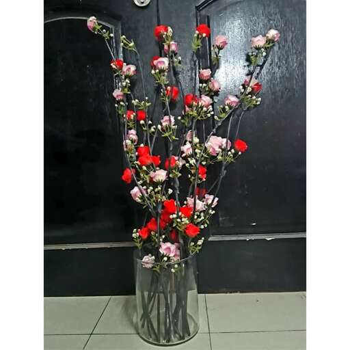 a vase filled with red and white flowers.