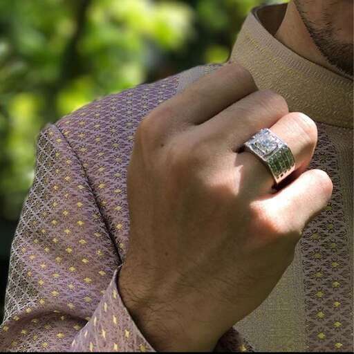 a man wearing a ring with a gold ring on his finger.