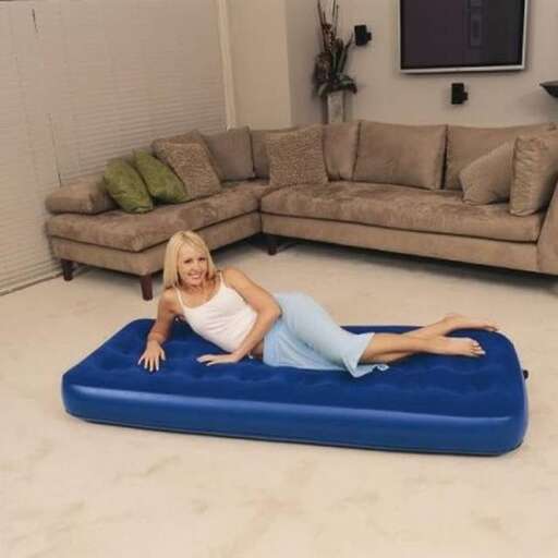 a woman is laying on a blue mat in a living room.