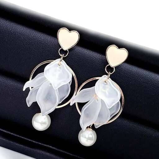 a pair of earrings with a heart shaped pendant
