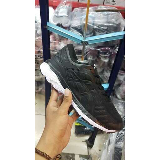 a customer shows off a sneaker that he is holding.