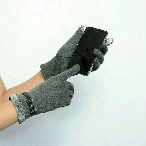 a person wearing a glove holding a cell phone.
