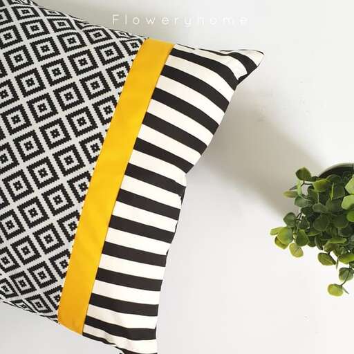a black and white striped pillow with a yellow stripe.