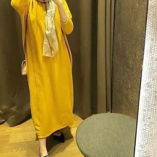 a woman in a yellow dress is taking a selfie in front of a mirror.