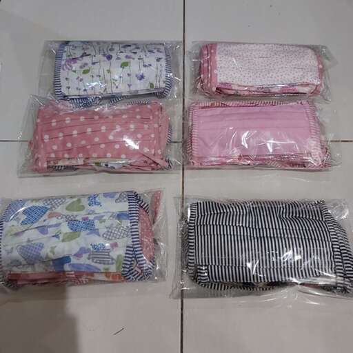 a group of folded clothes in plastic bags.