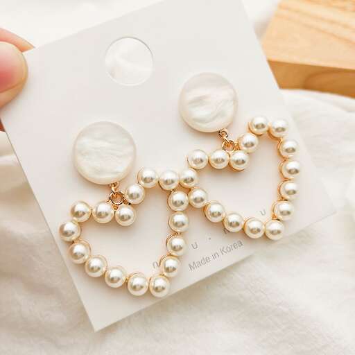 a pair of pearl necklaces with a heart shaped pendant.