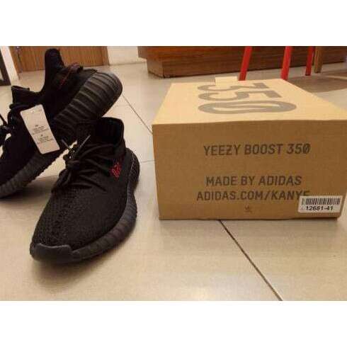 a pair of black shoes sitting on top of a brown box.