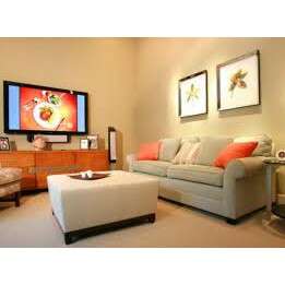 a living room with a couch, television, and pictures on the wall.