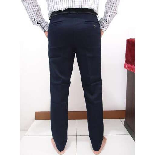 a man stands with his hands in his pockets.