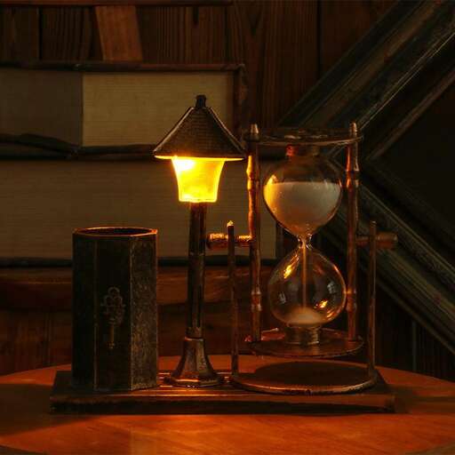 a lamp and a hourglass on a table.