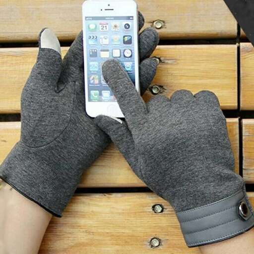 a person wearing gloves holding a cell phone.