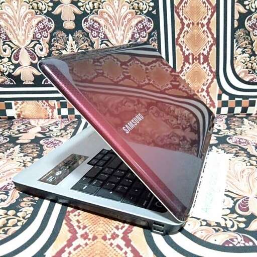 a laptop computer sitting on top of a rug.