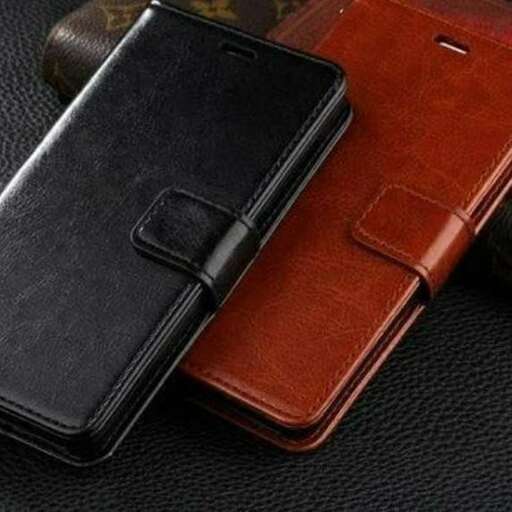 a leather case and a cell phone sitting on a table.