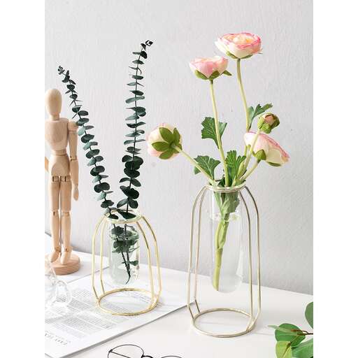 a vase with pink roses in it and a pair of glasses.