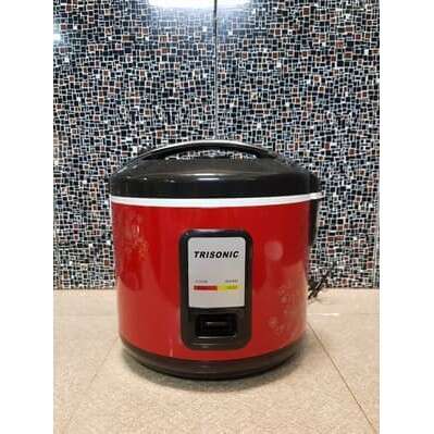a red and black crock pot sitting on a tile wall.