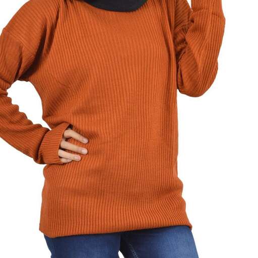 a woman wearing a sweater with her hands on her hips