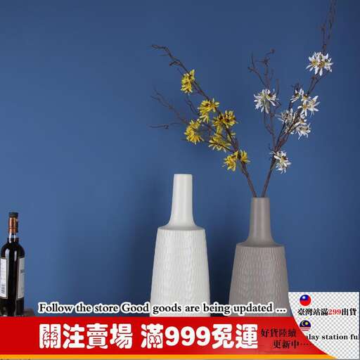 a blue wall behind a vase with flowers in it.