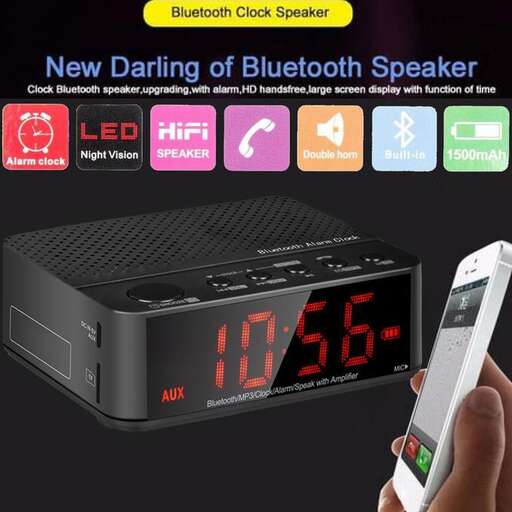 a person holding a phone next to a clock and a speaker.