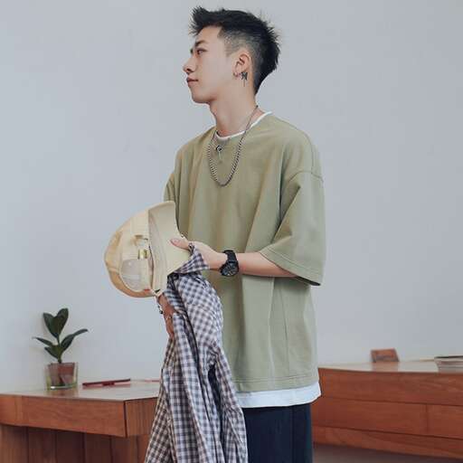 a man holding a shirt and a towel in his hand.