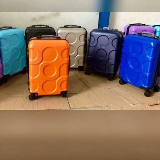 a group of colorful suitcases sitting on top of a wooden floor.
