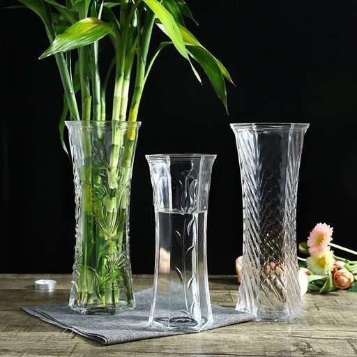 a table with three vases of flowers on it.