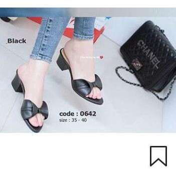 a woman wearing black sandals and a black purse.