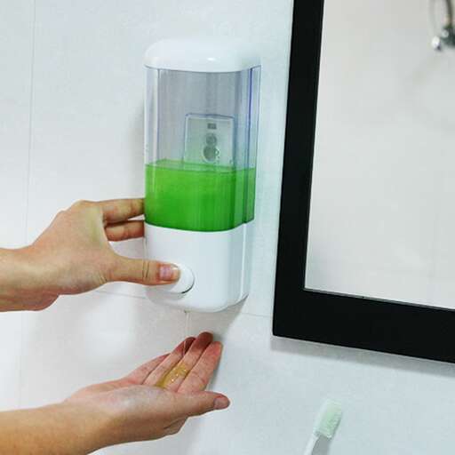 a person holding a green and white blender.
