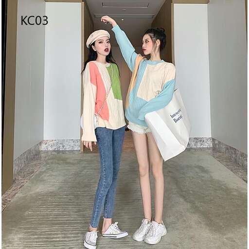 two girls are posing in a hallway with bags.