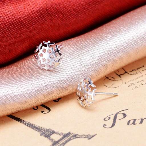 a pair of diamond earrings in sterling silver with a red background.