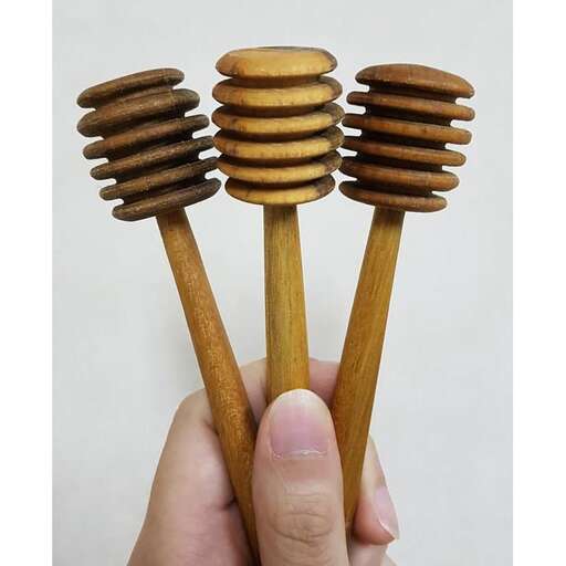 a hand holding a stack of wooden pins.