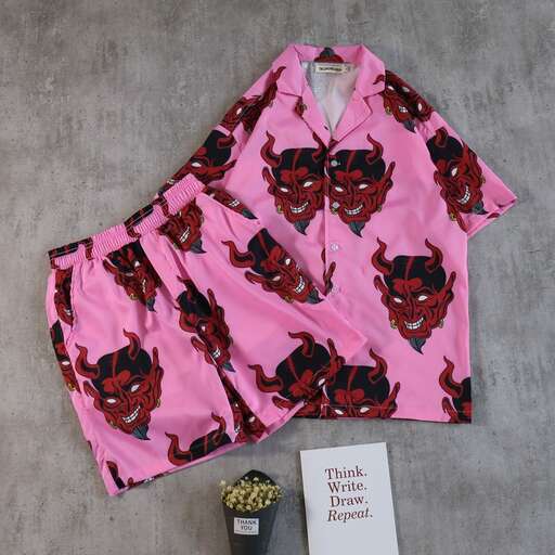 a pink shirt with a black and white cat print on it.