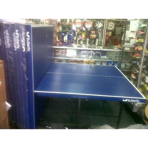 a blue ping pong table in a garage.