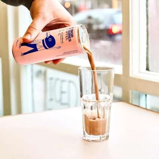 a person pouring a drink into a glass.