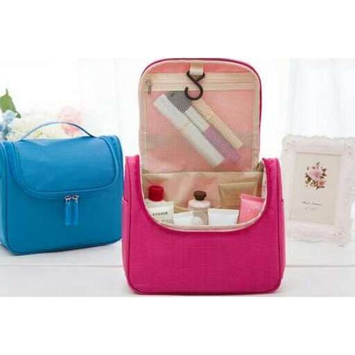 a pink suitcase with a blue bag on top of it.