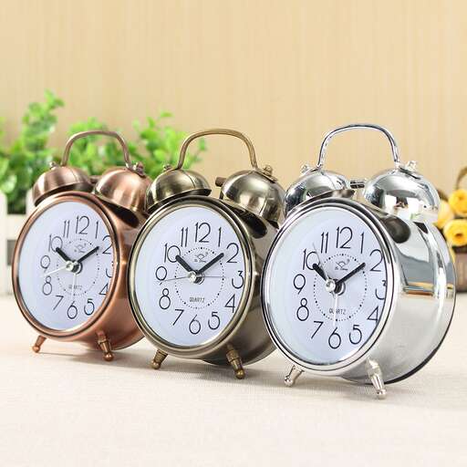 a collection of three alarm clocks on a table.