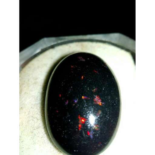 a black opal with a red and orange glow in it.