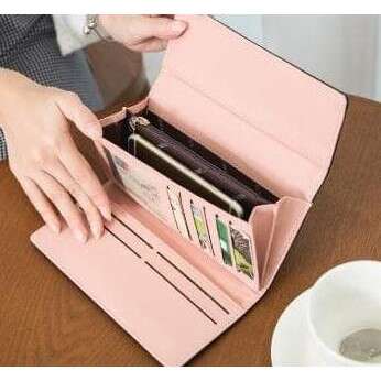 a person holding a box of mail over a table.