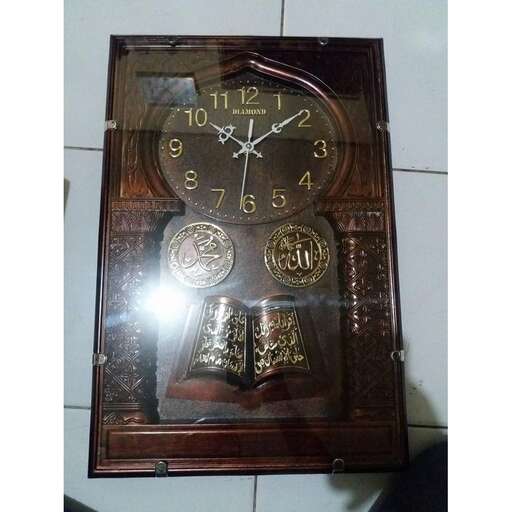 a clock with a wooden frame on a tiled floor.