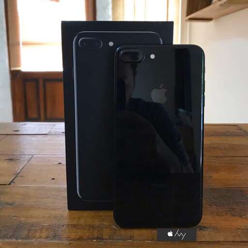 a black iphone case sitting on a wooden table.