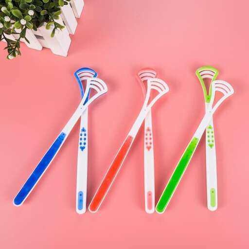 toothbrushes in different colors on a pink background