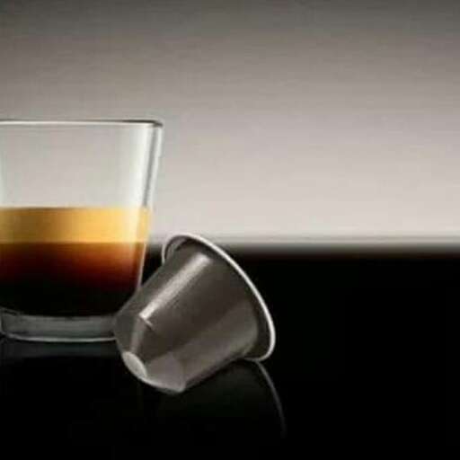 a glass of coffee with a spoon in it.