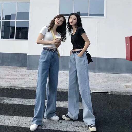 two girls standing on a street with a drink.