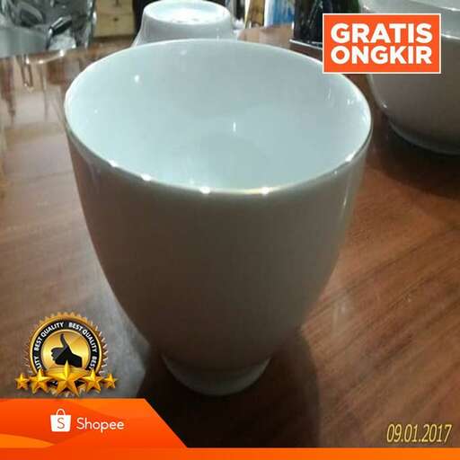 a white coffee cup sitting on top of a wooden table.