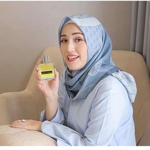 a woman in a headscarf holding a small electronic device.