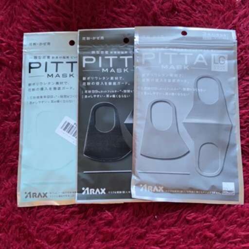 a pair of brand new plastic bags on a red surface.