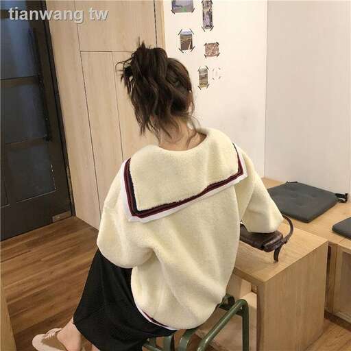 a woman sitting on a chair in front of a desk.