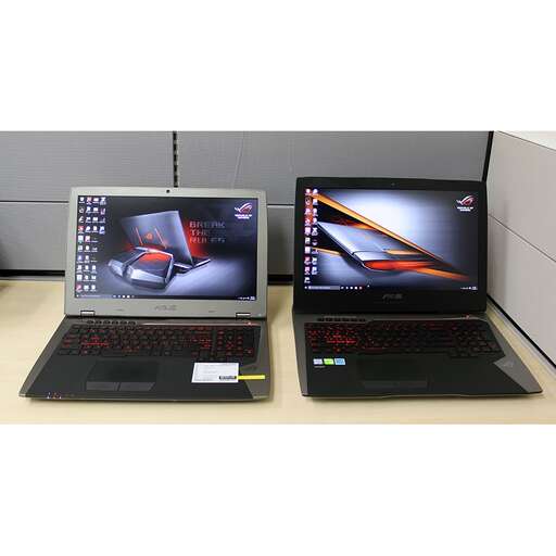 two laptop computers sitting side by side on a desk.