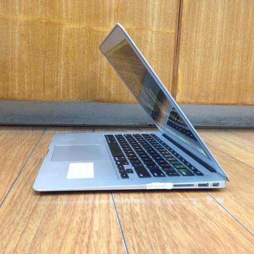 a laptop computer sitting on a wooden floor.
