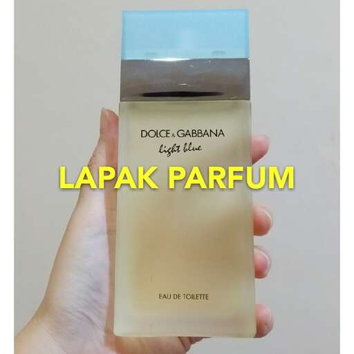 a hand holding a box of perfume