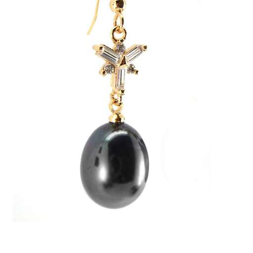 a black stone and gold pendant with a cross.